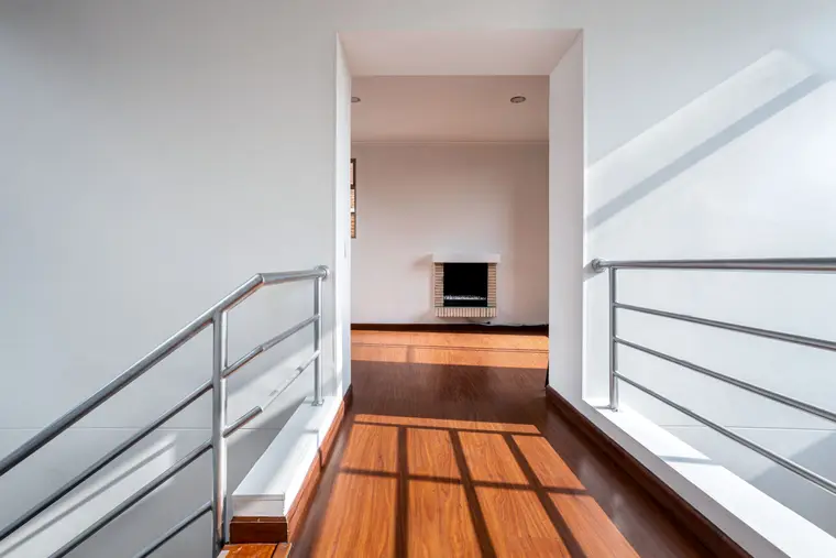 Wood-look flooring on an upstairs landing with metal railings