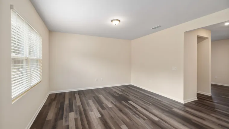 Gray wood-look vinyl plank in an empty room with a window blind