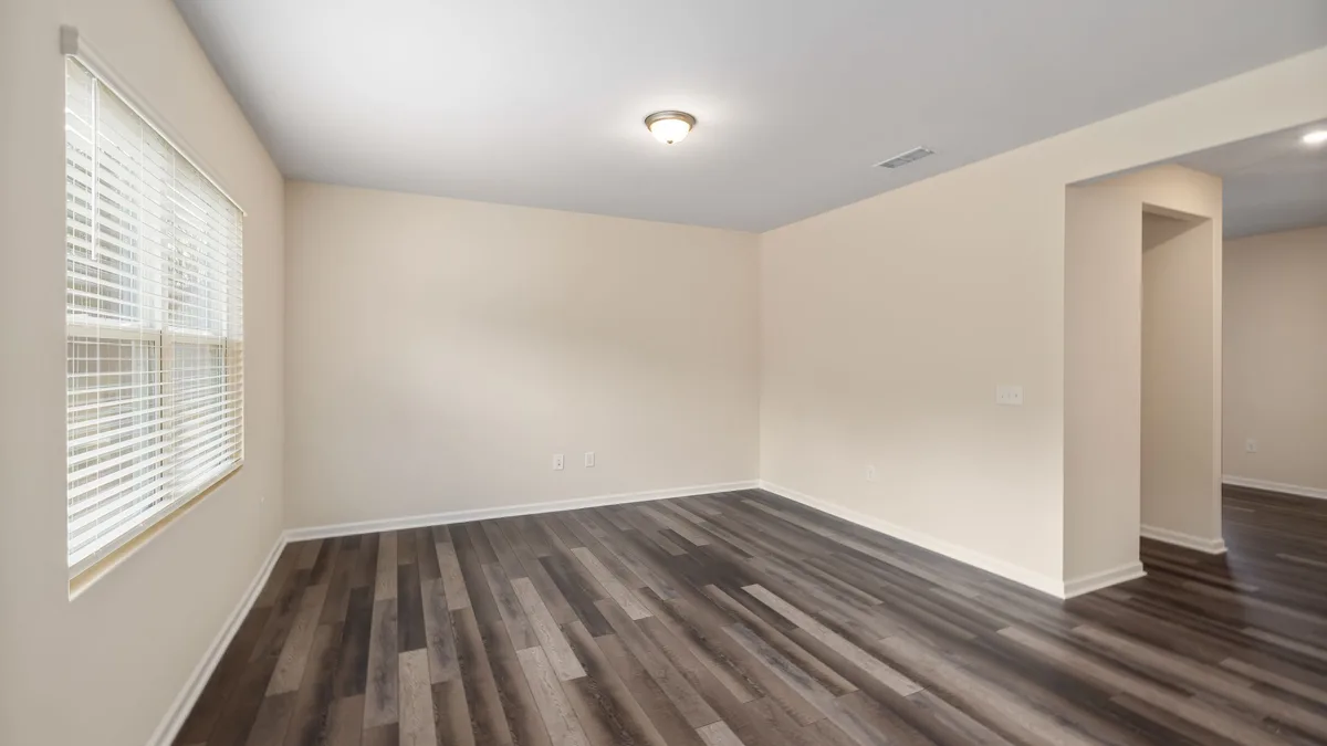 Gray wood-look vinyl plank in an empty room with a window blind